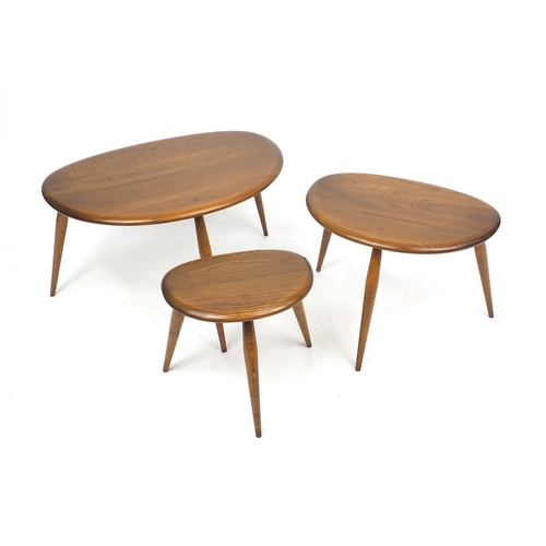 2028 - Ercol elm nest of three pebble tables, label to the inside of the larger, 40cm H