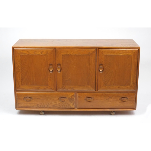 2018 - Ercol light elm sideboard fitted with three cupboard doors above two drawers, label to the interior,... 