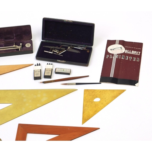 64 - Drawing instruments and rules including two cased planimeters, one by Stanley and three brass protra... 