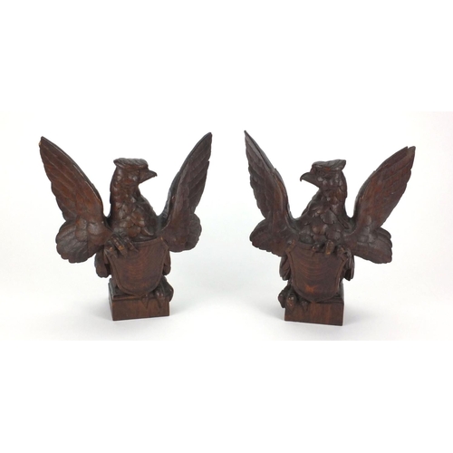 13 - Pair of carved wooden phoenixes with heraldic shields on square bases, each 23.5cm high
