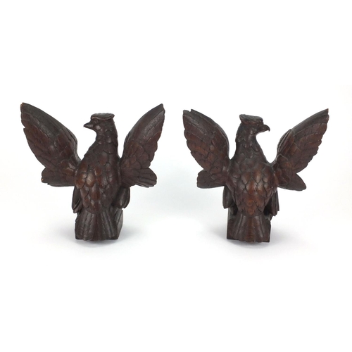 13 - Pair of carved wooden phoenixes with heraldic shields on square bases, each 23.5cm high