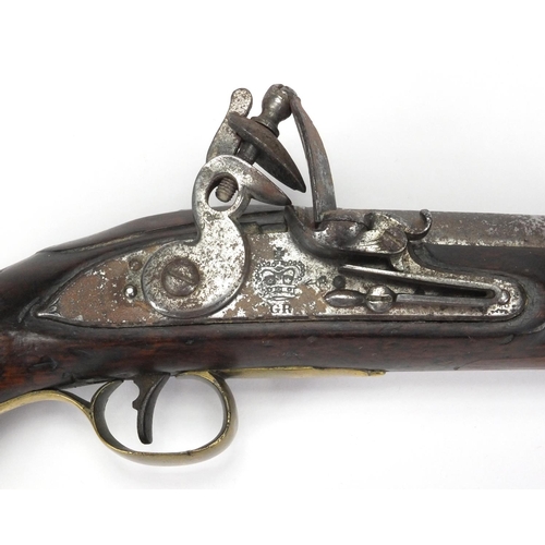 215 - Antique flint lock pistol with brass mounts, engraved Tower, GR emblem and proof marks, initialled T... 