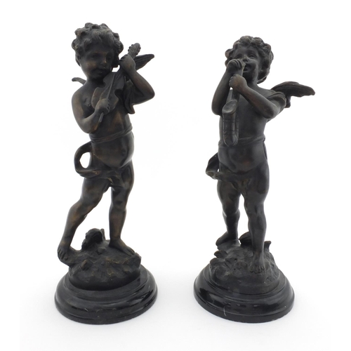 2138 - Pair of bronze cherub musicians raised on circular marbleised bases, the largest 32cm high