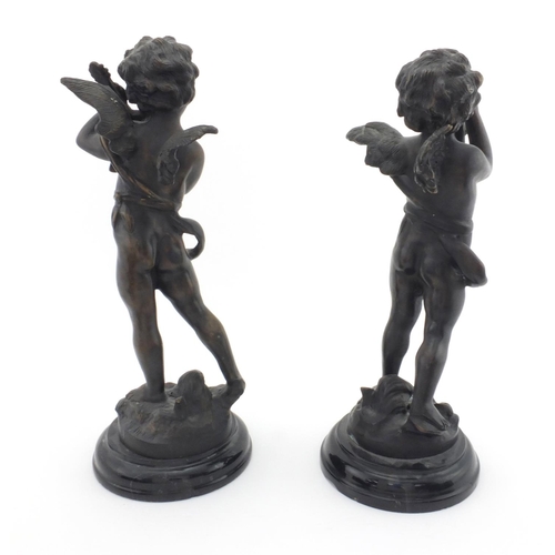 2138 - Pair of bronze cherub musicians raised on circular marbleised bases, the largest 32cm high