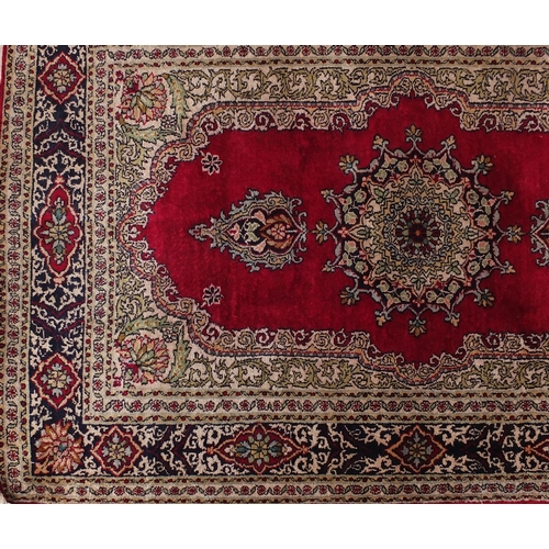 2031 - Rectangular Persian silk rug having all over floral motifs onto a red ground, 98cm x 63cm