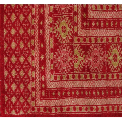 26 - Rectangular Persian rug having all over floral motifs onto a red ground, 190cm x 128cm