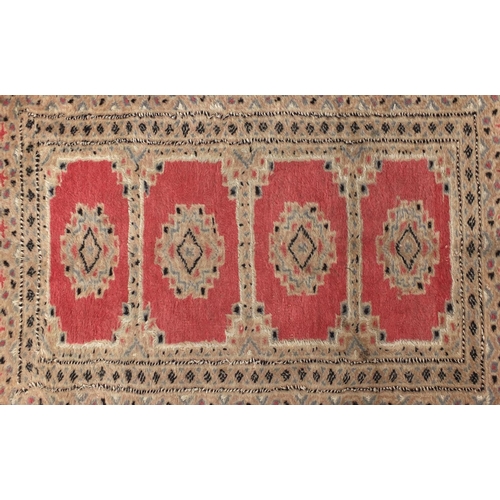 71 - Rectangular floral pattern rug onto a salmon ground, 110cm x 80cm