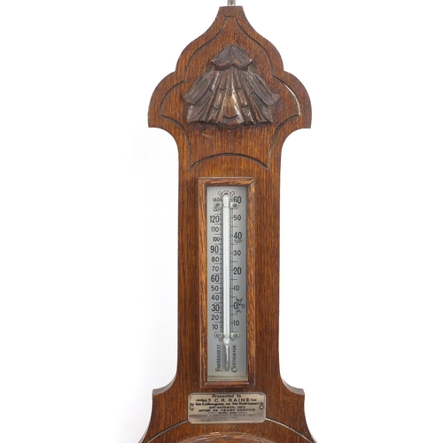 175 - Carved oak aneroid barometer with presentation plaque dated 1957, 67cm in lengh