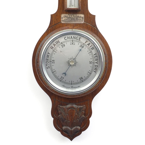 175 - Carved oak aneroid barometer with presentation plaque dated 1957, 67cm in lengh