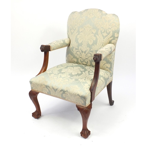 2046 - Walnut framed elbow chair carved with lion mask handles and with blue floral upholstery, 97cm high