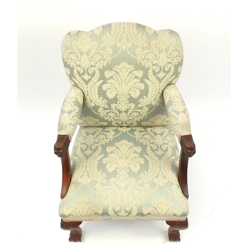 2046 - Walnut framed elbow chair carved with lion mask handles and with blue floral upholstery, 97cm high