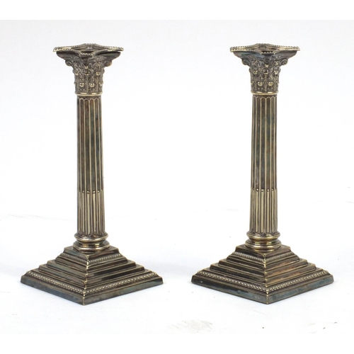 129 - Pair of silver plated Corinthian column candle sticks, 24cm high