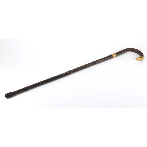 155 - Naturalistic wooden walking cane with gold coloured metal mounts, 86cm in length