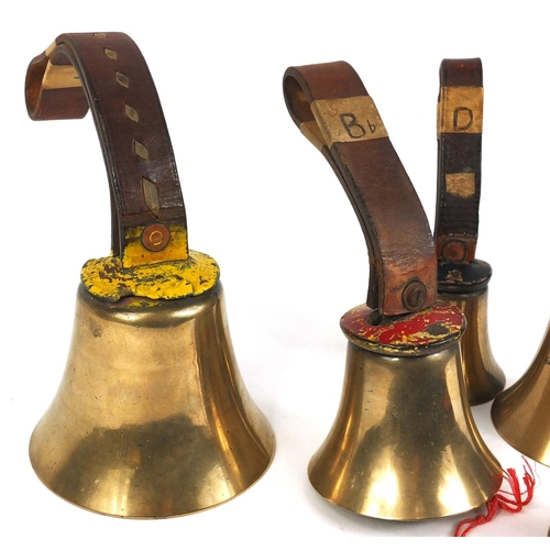 168 - Five bronzed metal church hand bells, with leather straps