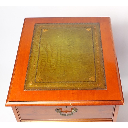 64 - Yew desk with tooled green leather insert and fitted with an arrangement of drawers, together with a... 