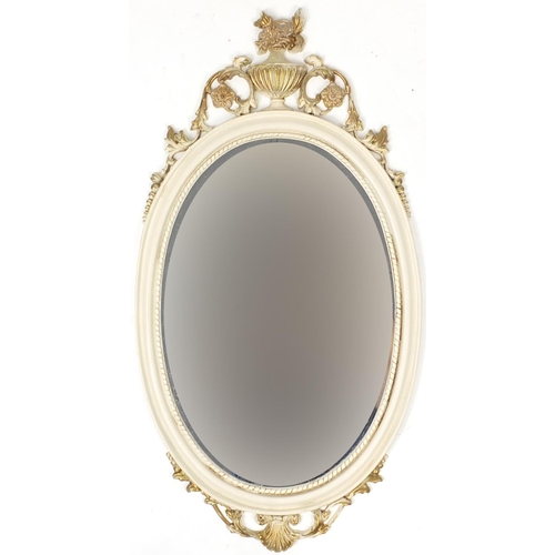 67 - Cream and gilt framed oval wall hanging mirror, 75cm x 40cm