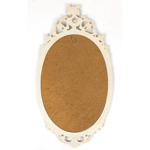 67 - Cream and gilt framed oval wall hanging mirror, 75cm x 40cm