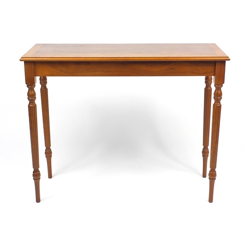 82 - Line inlaid yew console table raised on fluted legs, 75cm H x 95cm W x 37cm D