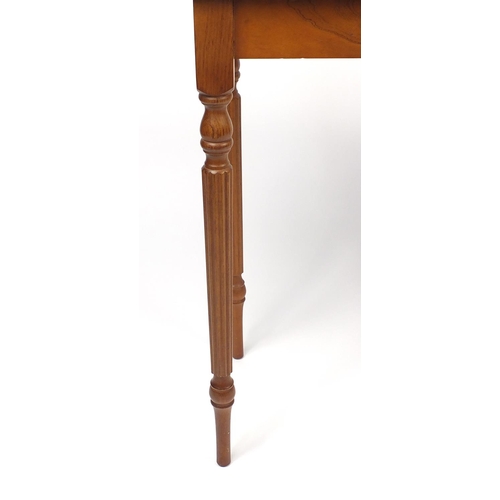 82 - Line inlaid yew console table raised on fluted legs, 75cm H x 95cm W x 37cm D