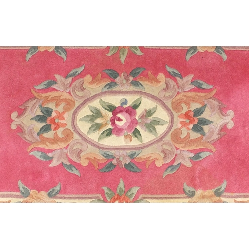 84 - Two pink ground floral rugs, each approximately 155cm x 90cm