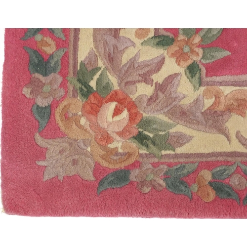 84 - Two pink ground floral rugs, each approximately 155cm x 90cm