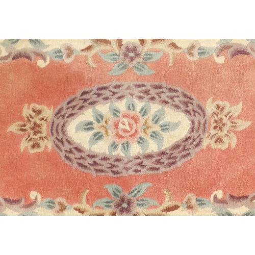 84 - Two pink ground floral rugs, each approximately 155cm x 90cm