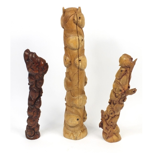 59 - Three carved wooden columns of schools of fish, the largest 82cm high