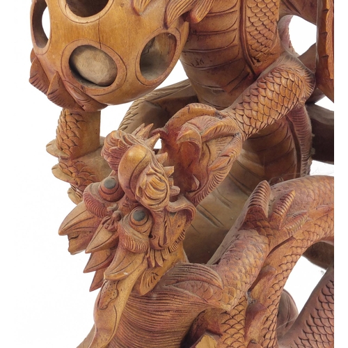 2044 - Floor standing carved wooden sculpture of two Chinese dragons chasing the pearl, 108cm high