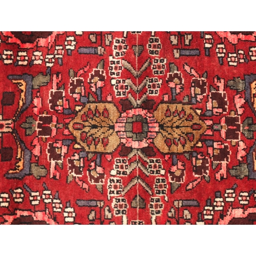 2050 - Persian Shiraz rectangular carpet runner, having all over floral motifs onto a dark red ground, 277c... 
