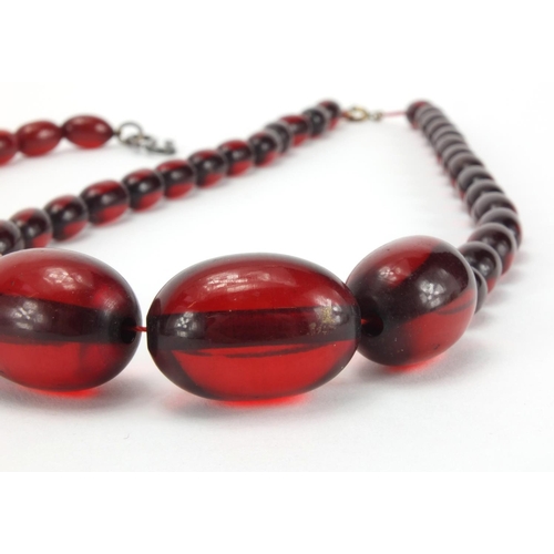 1060 - Four cherry amber coloured bead necklaces, the largest 80cm in length, approximate weight 205.0g