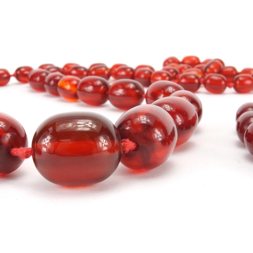 1060 - Four cherry amber coloured bead necklaces, the largest 80cm in length, approximate weight 205.0g