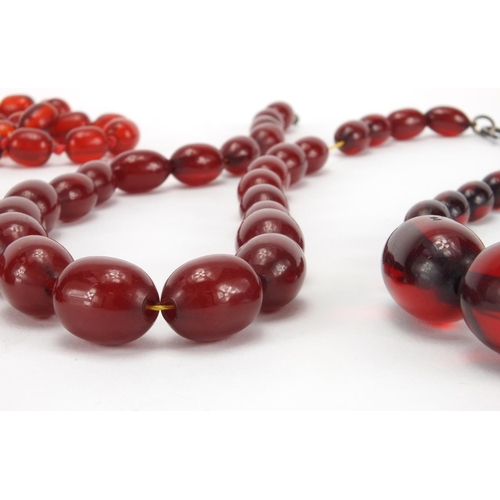 1060 - Four cherry amber coloured bead necklaces, the largest 80cm in length, approximate weight 205.0g