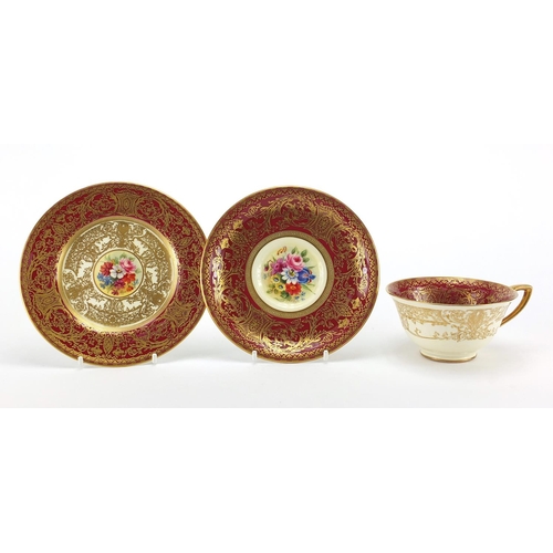 707 - Royal Worcester trio hand painted with flowers within gilt foliate boarders onto a red ground, signe... 