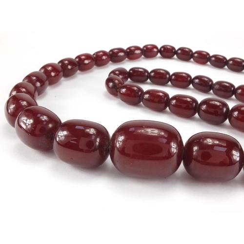 1058 - Cherry amber coloured bead necklace, 64cm in length, approximate weight 77.5g