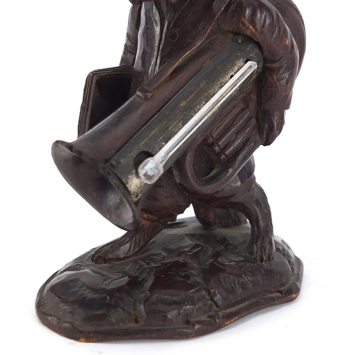 46 - Black forest desk thermometer carved in the form of a dog holding a trombone, 13cm high