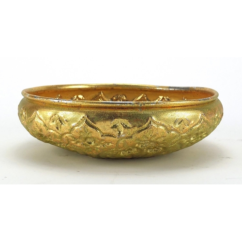 637 - Turkish gilt metal bathroom bowl embossed with stylised flowers and foliage, 21cm in diameter