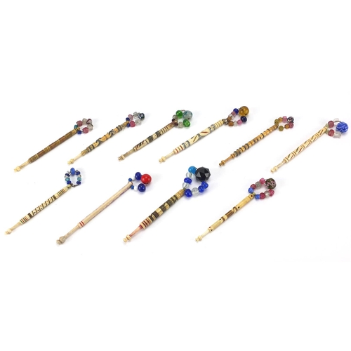 146 - Ten sewing interest Victorian bone bobbins with glass beaded ends, the largest 9.5cm in length