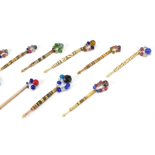 146 - Ten sewing interest Victorian bone bobbins with glass beaded ends, the largest 9.5cm in length