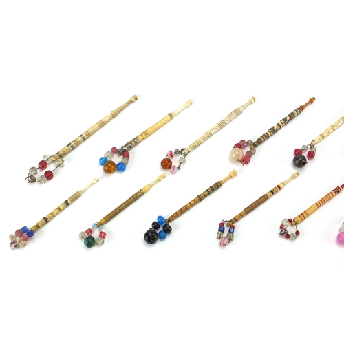145 - Fifteen sewing interest Victorian bone bobbins with glass beaded ends, the largest 9.5cm in length