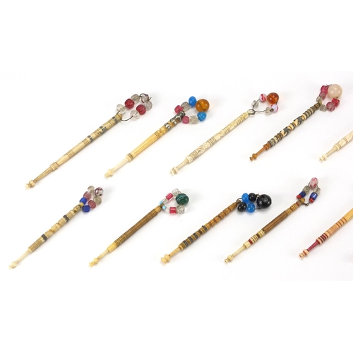 145 - Fifteen sewing interest Victorian bone bobbins with glass beaded ends, the largest 9.5cm in length