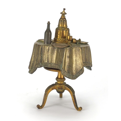 91 - Novelty brass bell push in the form of a dining table, 14cm high