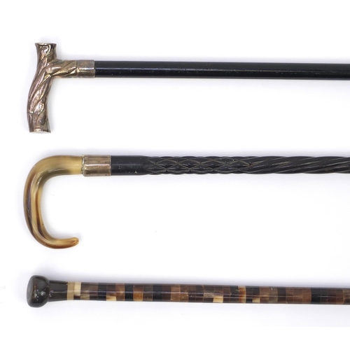 125 - Segmented bone walking cane together with two ebonised examples one with silver handle and one with ... 