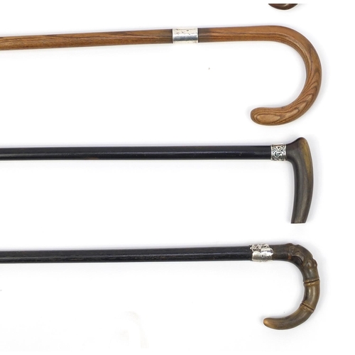 132 - Five wooden walking canes, including a sword stick, three with horn handles, the largest 86cm in len... 