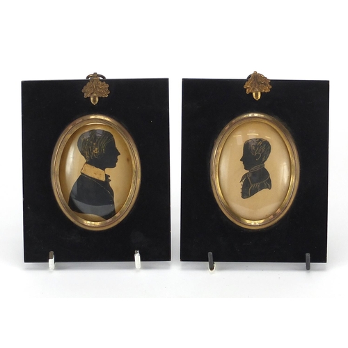14 - Pair of 19th century silhouettes, one of a male one of a female, both housed in black ebonised frame... 