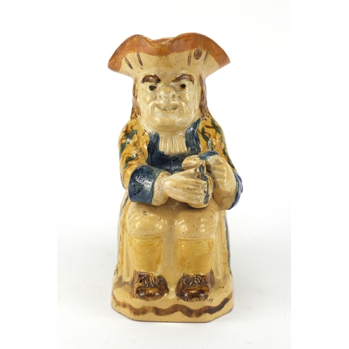 685 - 18th Century Ralph Wood type pottery toby jug in creamware colours, seated wearing a blue striped ye... 