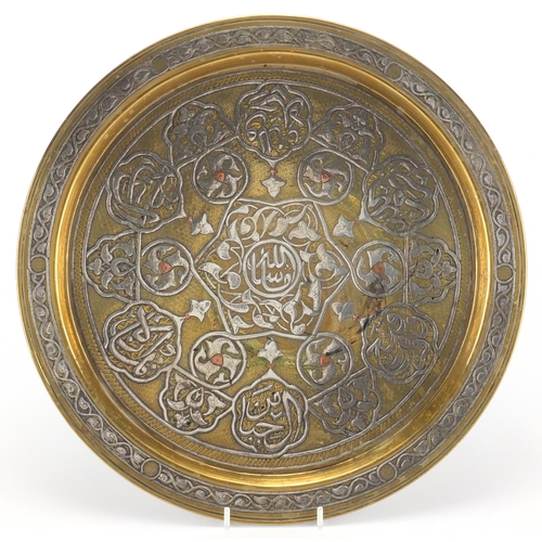 635 - Egyptian Cairoware brass tray with silver inlay, decorated with script and foliage, 32cm in diameter