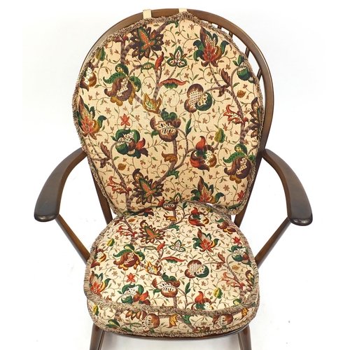 2061 - Ercol elm stick back rocking chair with floral upholstery, 96cm high