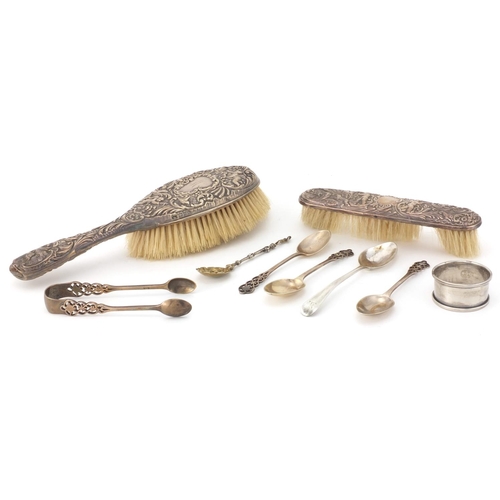 2437 - Silver items comprising two dressing table brushes, four tea spoons, a Georgian spoon and napkin rin... 