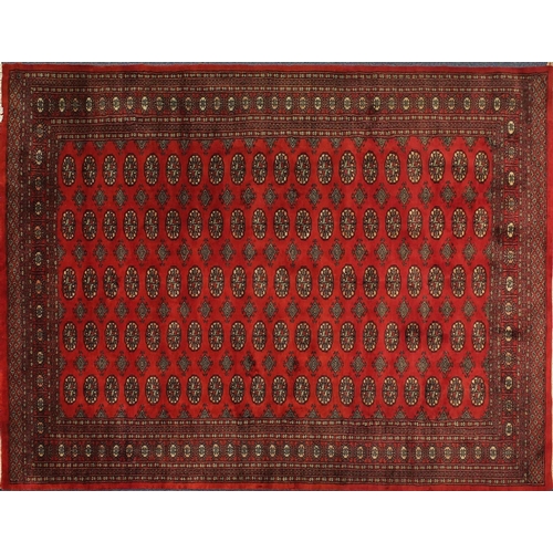 2035 - Rectangular Pakistan Bokhara design rug onto a dark red ground, 274cm x 183cm