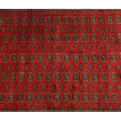 2035 - Rectangular Pakistan Bokhara design rug onto a dark red ground, 274cm x 183cm